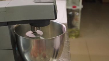 Ellerinde spatula ve mikser eklenerek mutfakta hamur işi hazırlayan tanınmayan fırıncının yan görüntüsü