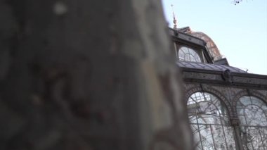 Camdan pencereleri olan eski bir kale ağaçları yansıtıyor, Palacio de Cristal, Retiro Park, Madrid, İspanya