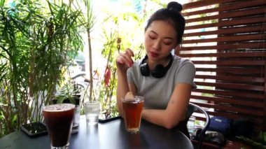 Kafede sıcak çay hazırlayan Asyalı güzel bir kadının yakın çekimi. 