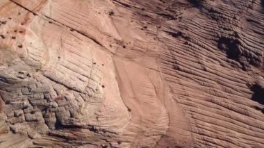 Amerika Birleşik Devletleri 'ndeki Vermillion Cliffs Ulusal Anıtı' nda güneşli bir günde sert kayalık oluşumların ve kumlu zeminin nefes kesici insansız hava aracı görüntüsü