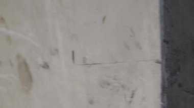 Çekici, şık, genç, sarışın erkek. Tozlu odada pencerenin kenarında oturuyor. Duvarları aşınmış ve başka tarafa bakıyor.