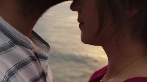 作物認識できないロマンチックなカップルキスしながら立っている間ラフ岩崖の端に海に対して日没 — ストック動画
