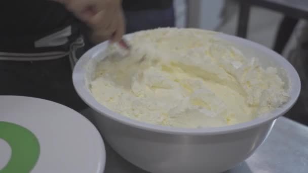 軽い台所で働いている間ボールのケーキのための新鮮な甘いクリームを混合する作物の実時間 — ストック動画