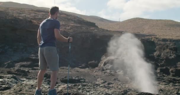 Olgun Bir Adamın Gündelik Kıyafetleriyle Deniz Gayzerinin Yakınındaki Volkanik Deniz — Stok video