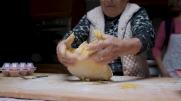 調理のための材料を準備しながら キッチンでテーブルに立って 生地を混練シニア女性が食欲をそそるTortelini — ストック動画