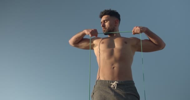 Muscular Male Bodybuilder Naked Torso Standing Seashore Doing Exercises Resistance — Stock Video