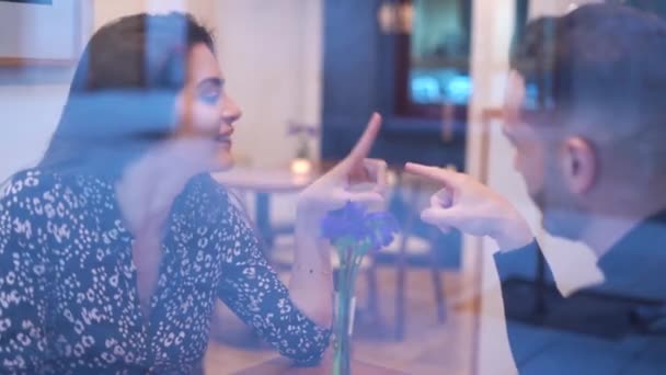 在约会期间 通过爱情男人与女友触摸食指和亲吻手的窗口 实时地在餐馆里接吻 — 图库视频影像