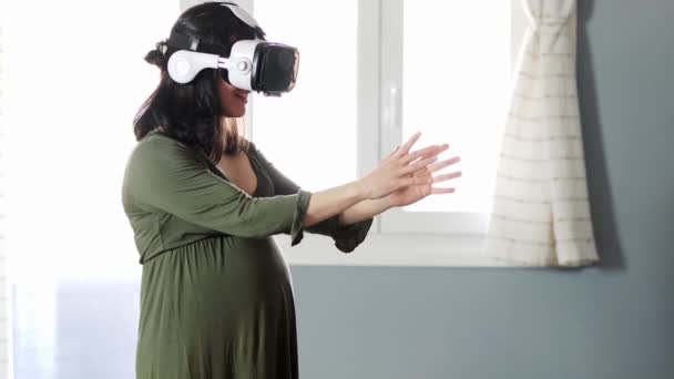 年轻而沉着的孕妇 黑发长裙 在家里的当代耳机里体验着虚拟现实 — 图库视频影像