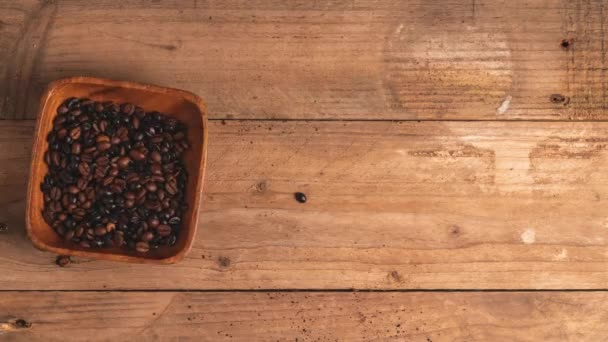 烤新鲜咖啡豆在褐色杯子中的倒立动作动画 木桌上的爱情和咖啡 — 图库视频影像