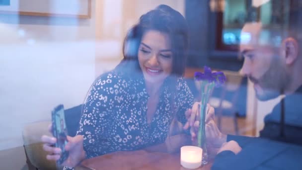 낭만적 카페테리아에 앉아있는 전화에 비디오를보고 긍정적 커플의 실시간보기 — 비디오