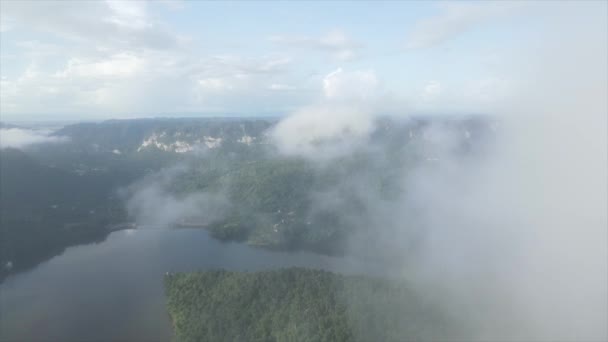 缓慢移动的无人驾驶飞机俯瞰着漂浮在弯曲的河流上的灌丛积云 其中有森林覆盖的海岸和乡村房屋 — 图库视频影像