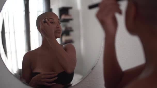 머리가 대머리인 아프리카 미국인 거울을 들여다보고 화장을 하면서 기초를 — 비디오