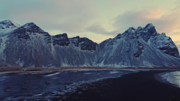 冰岛冬夜 白雪覆盖的山脊映衬着多云的落日天空 — 图库视频影像