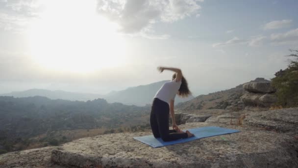 Tanımlanamayan Zayıf Bir Kadının Kayalık Dağda Yoga Yaparken Dirseklerini Mindere — Stok video