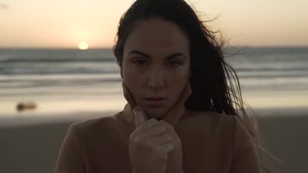 レバンテの日没で風の強い日にビーチに立っている間 夢のような女性の調整コート — ストック動画