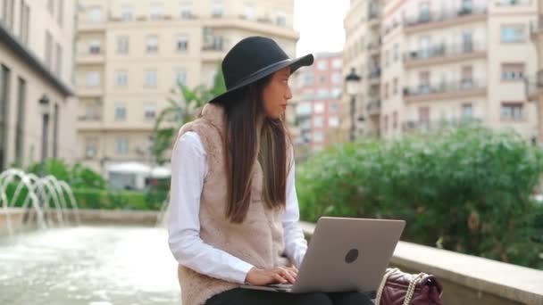 Mujer Hispana Concentrada Escribiendo Netbook Cerca Del Edificio Con Café — Vídeo de stock