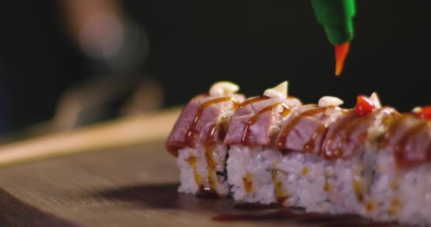 潘的特写镜头是一个默默无闻的厨师 一边慢吞吞地在木板上准备美味的海鲜 一边用生鱼片和米饭配上火红酱汁 — 图库视频影像