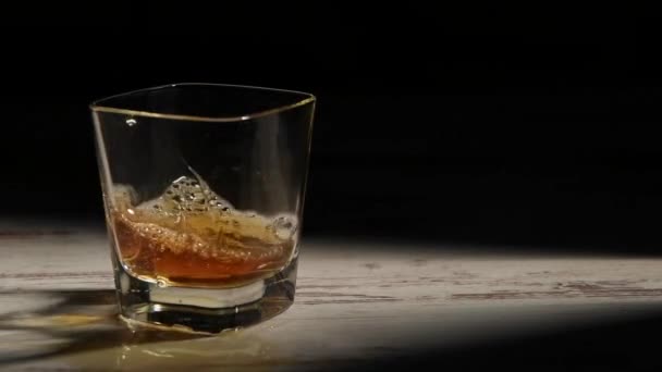 Person Fyllning Transparent Glas Med Bourbon Träbord Strålar Mot Svart — Stockvideo