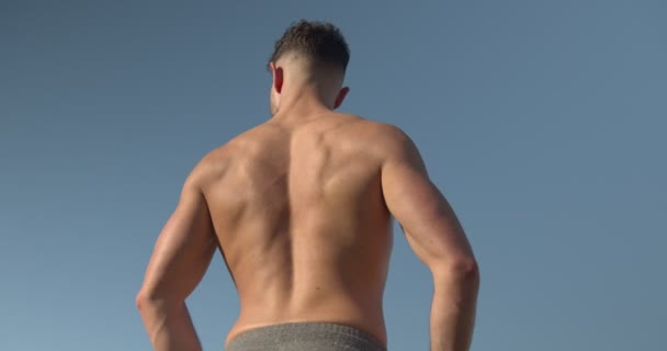 Back View Muscular Male Bodybuilder Naked Torso Standing Seashore Doing — Stock Video