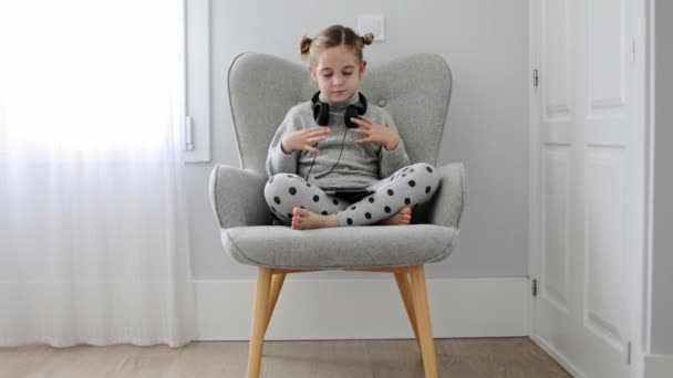 Pełne Ciało Bosej Dziewczyny Siedzącej Skrzyżowanymi Nogami Fotelu Słuchającej Piosenek — Wideo stockowe