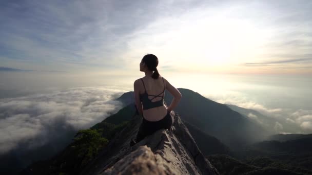 远足的女运动员坐在远水山顶上享受着成就的倒影 — 图库视频影像