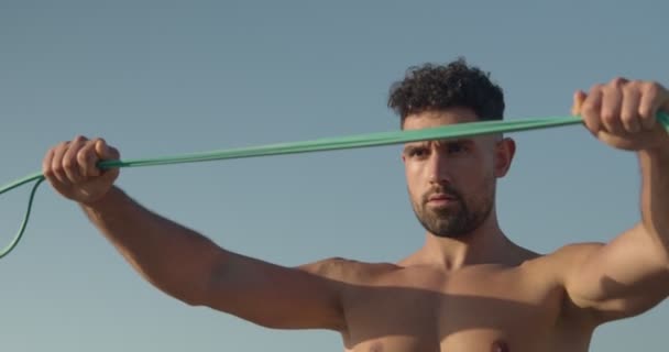 Muscular Fisiculturista Masculino Com Tronco Praia Fazendo Exercícios Com Banda — Vídeo de Stock