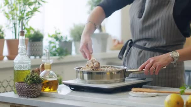在厨房电炉上的不锈钢平底锅中 用木制水壶煮肉饼的无名小卒的真实时间 — 图库视频影像