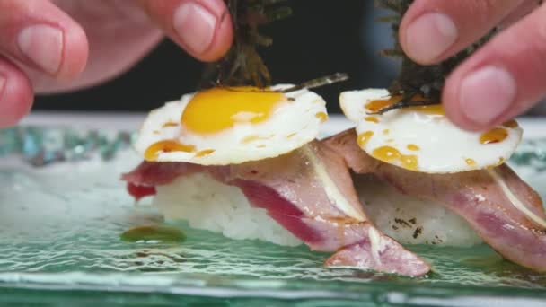 在准备日本菜的时候 蔬菜厨师在寿司中加入海草 寿司由炒鸡蛋和饭团上的鱼片组成 — 图库视频影像