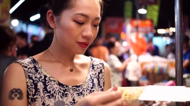 朱兵衛夜市に立ち 箸でアジア料理を楽しみながら揚げ餃子を食べる民族女性 — ストック動画