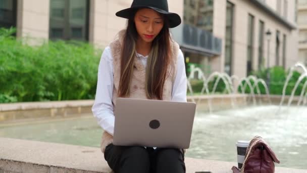 Skoncentrowana Latynoska Kobieta Pisząca Netbooku Pobliżu Budynku Kawą Wynos Ulicy — Wideo stockowe