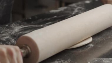 Adam mutfakta pizza pişiriyor.