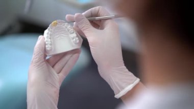 Modern klinikte çalışırken cerrahi aletlerle hasta için çene kalıbı yapan tanınamayan bir ortodontist