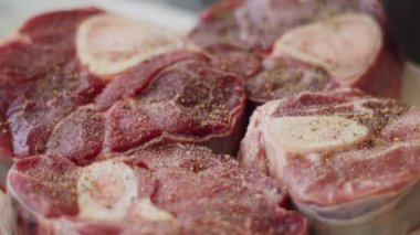 Osobuco pişirmek için baharatlı pişmemiş dana incik kemikli gerçek zamanlı anonim kadın.