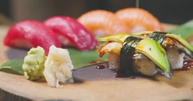 Japon kafesinde taze suşi ve soya sosuyla kaplanmış siyah beyaz susam dökülüyor.