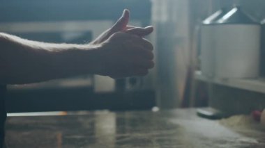 Çağdaş kafe mutfağında yemek pişirirken yumuşak hamurdan topa şekil veren tanınmayan erkek şef.