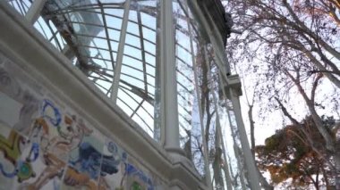 Camdan pencereleri olan eski bir kale ağaçları yansıtıyor, Palacio de Cristal, Retiro Park, Madrid, İspanya