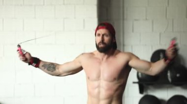 Genç adam spor salonunda egzersiz yapıyor.