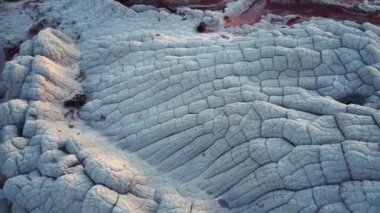 Arizona 'daki Vermilion Cliffs Ulusal Anıtı' ndaki eşsiz kumtaşı beyaz cep alanının engebeli yüzeyinin insansız hava aracı görüntüsü.