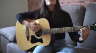 Evde gitar çalan kadın.