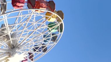 Barcelona 'da güneşli bir günde Tibidabo Lunaparkı' nda güneşli mavi gökyüzüne karşı renkli kamaraları olan modern dönme dolabın altından.