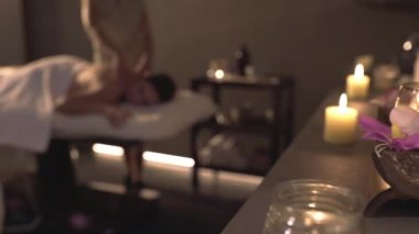 Masaj seansında mum ve çiçeklerle dolu kaplıcada gözleri kapalı dinlenen olgun çiftin görüntüsünü terk et.
