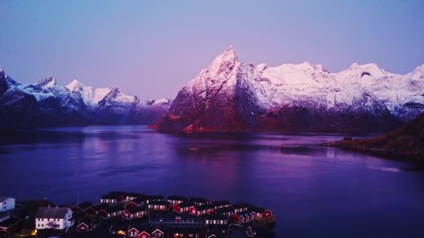 挪威罗浮敦群岛沿海小镇居民住宅的风景如画的空中景观 这些住宅的岩石雪山与黄昏的天空相映成趣 — 图库视频影像