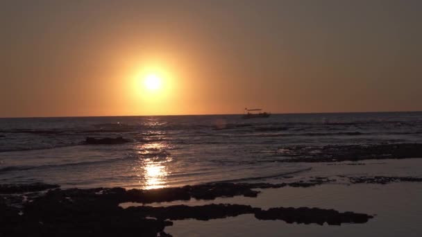 レバノンの雲のない日没の空に対する泡立った波と無限に熟した海に浮かぶ現代のボートの息をのむような景色 — ストック動画