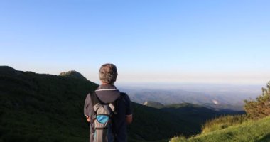 Yetişkin bir adamın dağlarda yürüyüşünün manzaralı görüntüleri.