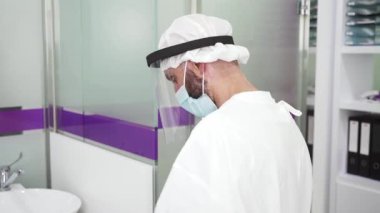 Laboratuvarda koruyucu kıyafetli ve maskeli bilim adamı