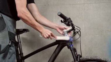 Atölyede fırçalı bisiklet tekerinin tanınmayan erkek tamirci temizlik ekipmanı kasedi