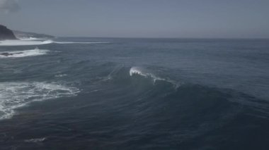 Güçlü köpüklü dalgaların İHA görüntüsü Tenerife adasında dalgalı deniz kıyısında süzülüyor