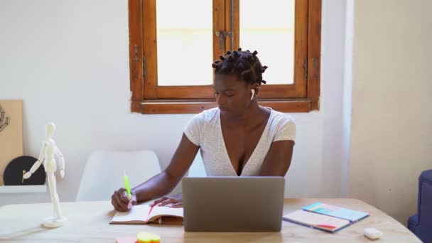 アフリカ系アメリカ人女性のフリーランスは ノートパソコンを持ちながらプロジェクトに取り組んでいる — ストック動画