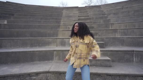 非洲裔美国女性一边一边一边一边一边一边一边听音乐 一边在楼梯上弹奏鼓掌声的侧景 — 图库视频影像