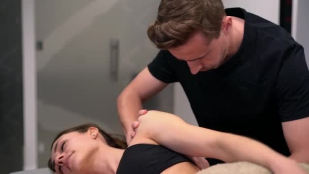Male Physical Therapist Examining Shoulder Arm Joint Mobility Female Patient — Stock Video